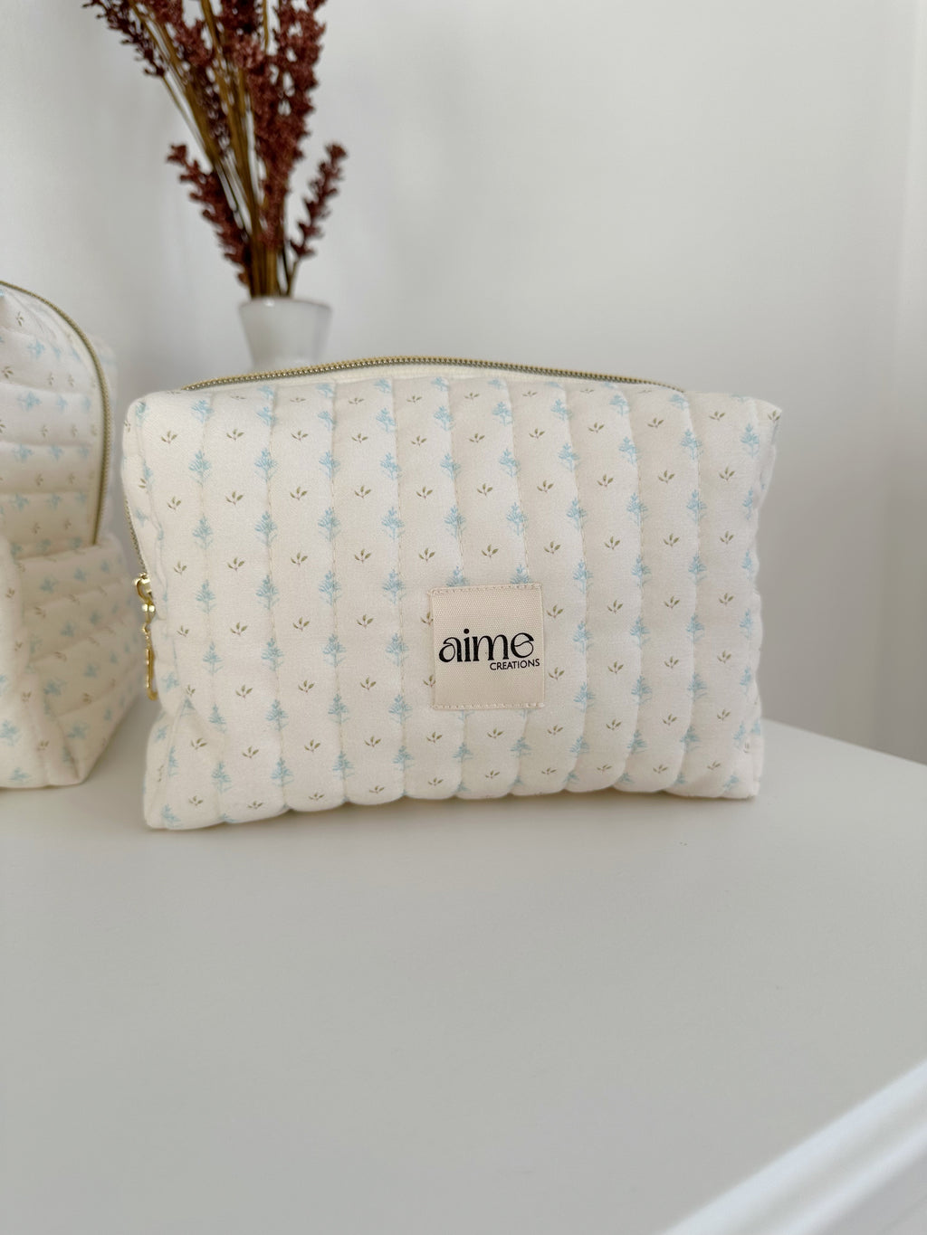 beauty case color avorio con dettagli di foglioline azzurre