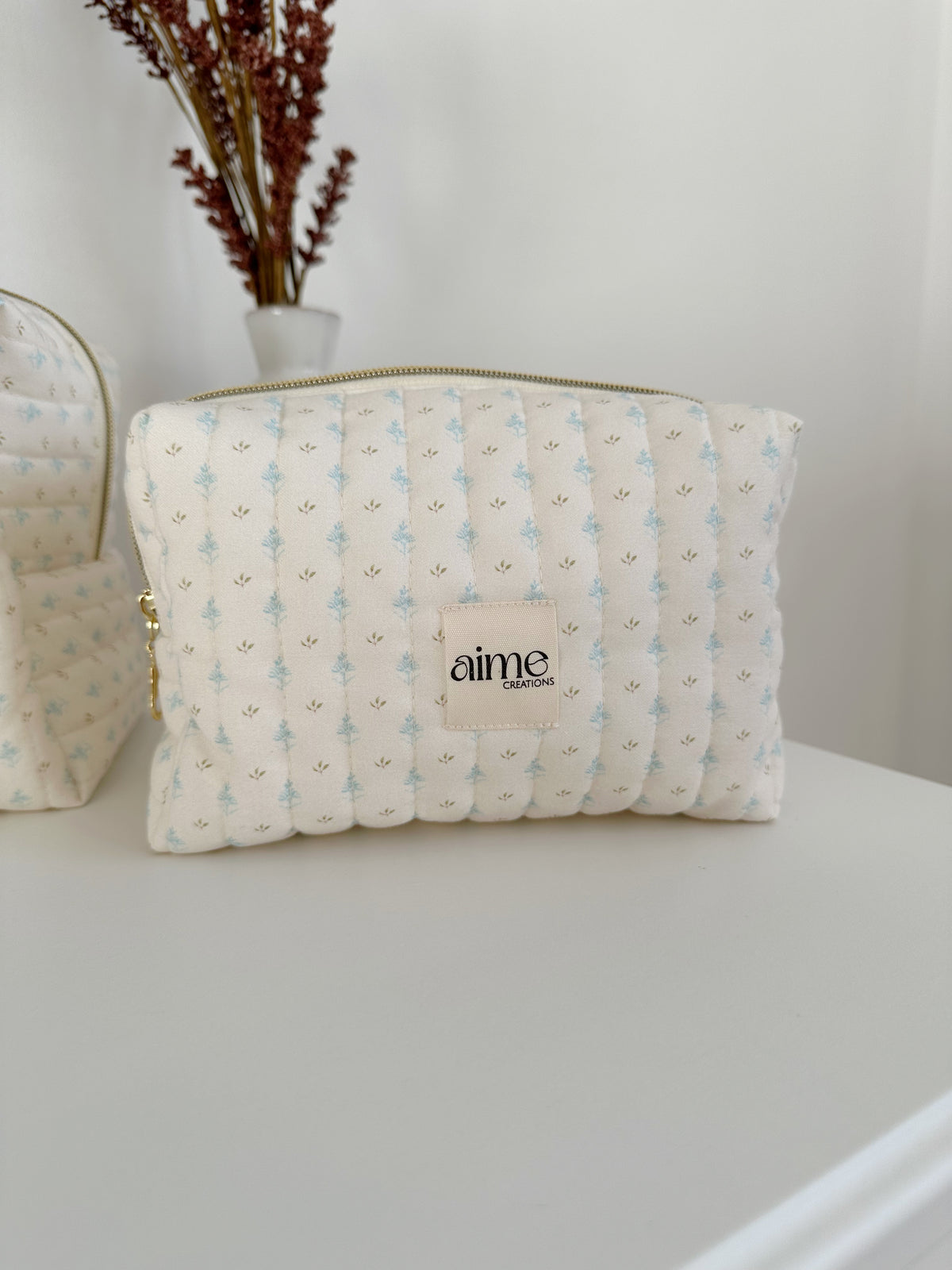 beauty case color avorio con dettagli di foglioline azzurre