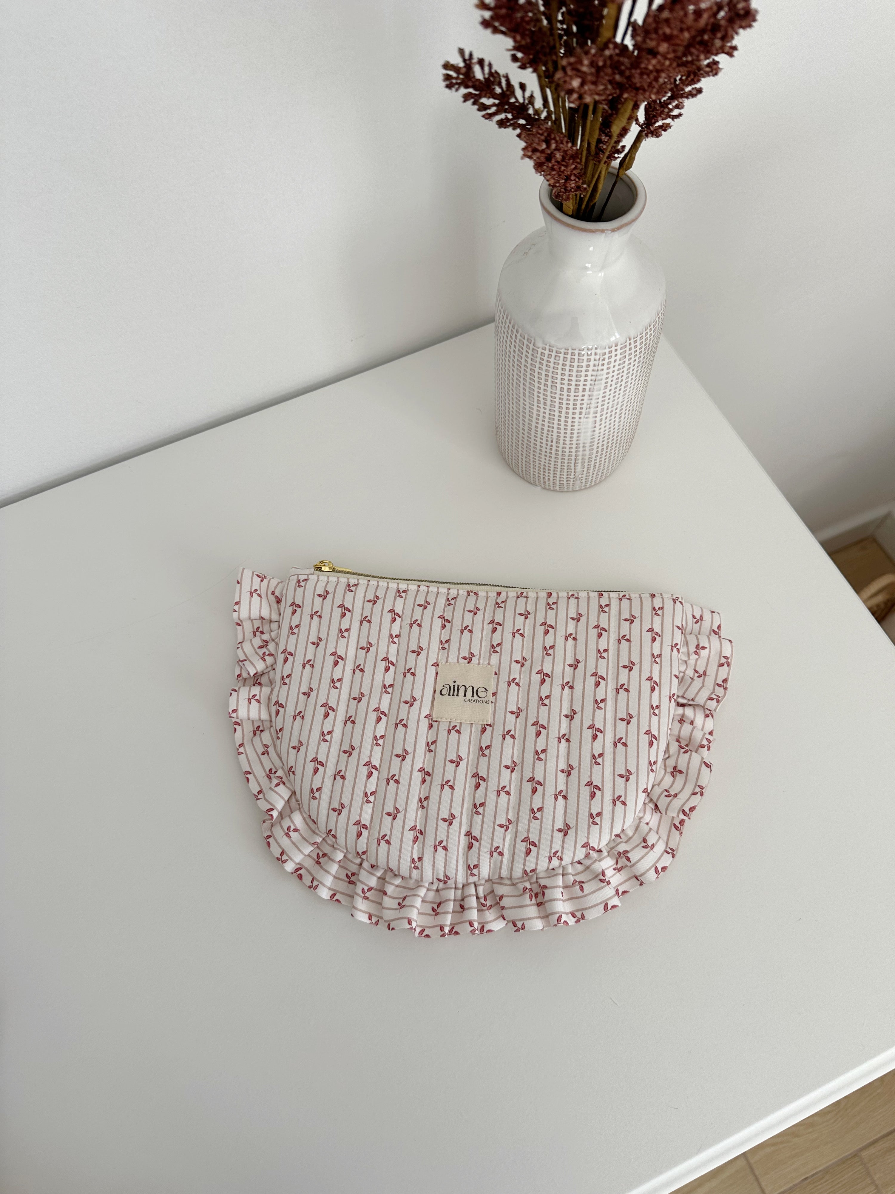 pochette artigianale con volant su fondo beije e foglie marron
